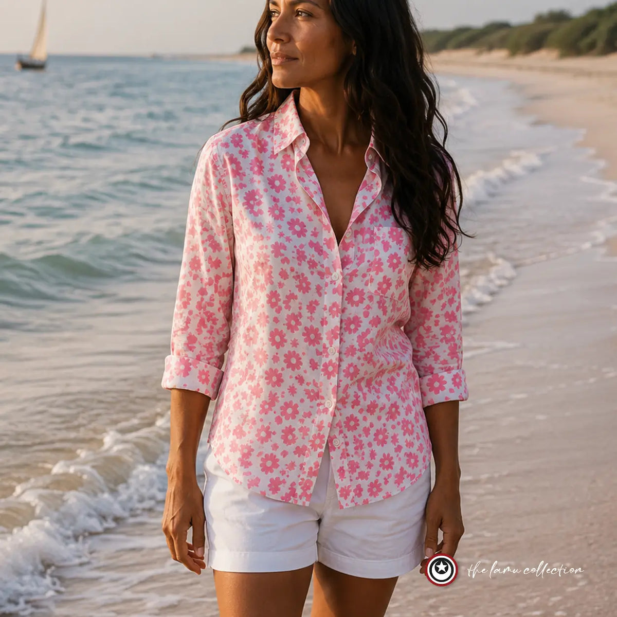 Woman wearing a pink floral Limuru shirt on the beach.