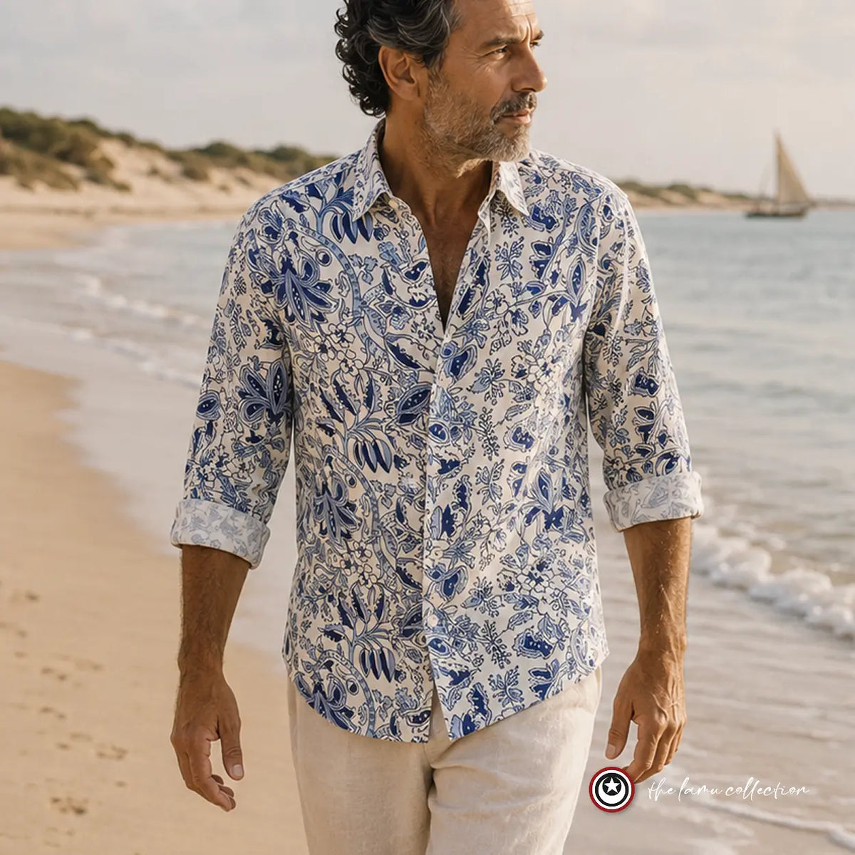 Man wearing a blue and white patterned shirt on the beach.
