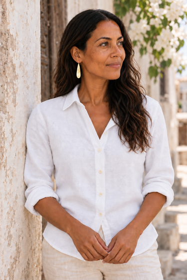Model wearing hammered brass Machozi earrings and a white linen shirt.