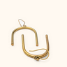 Mlangoni brass earrings on a light background.