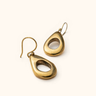 Mvua brass earrings on a light background.