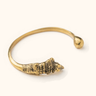 Mamba brass bangle on a light background.