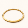 Mduara Hammered recycled brass bangle on a warm ivory background.